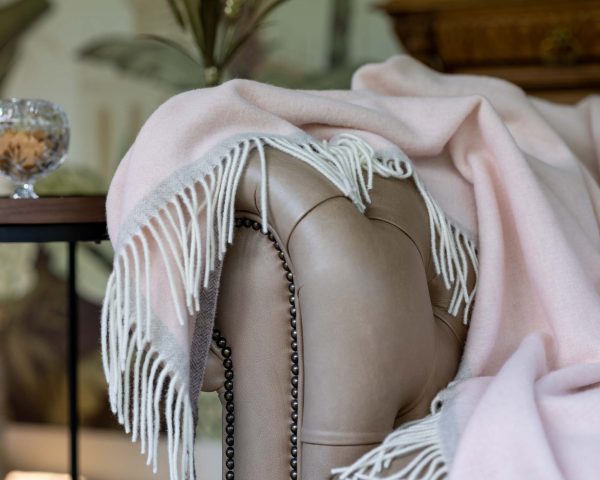 Roze merino-kasjmier plaid Milano Rosa Orlo, elegant opgevouwen met zachte structuur en luxe afwerking.