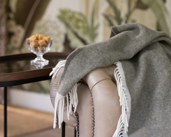 Groene merino-kasjmier plaid Milano Verde Orlo, elegant opgevouwen met zichtbare zachte structuur en luxe uitstraling.